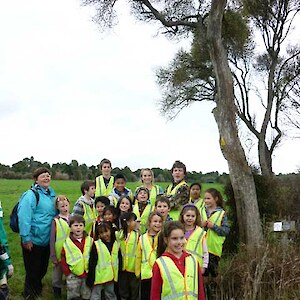 Hedgehope School pupils with teacher, Shirley Platt, stand under a mature Olearia hectorii.