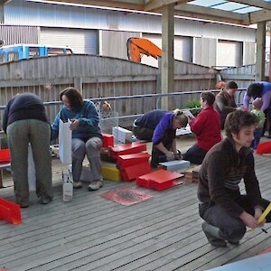 Volunteers get together to assemble rat traps for the community-driven Habitat restoration project share stories and scones. .